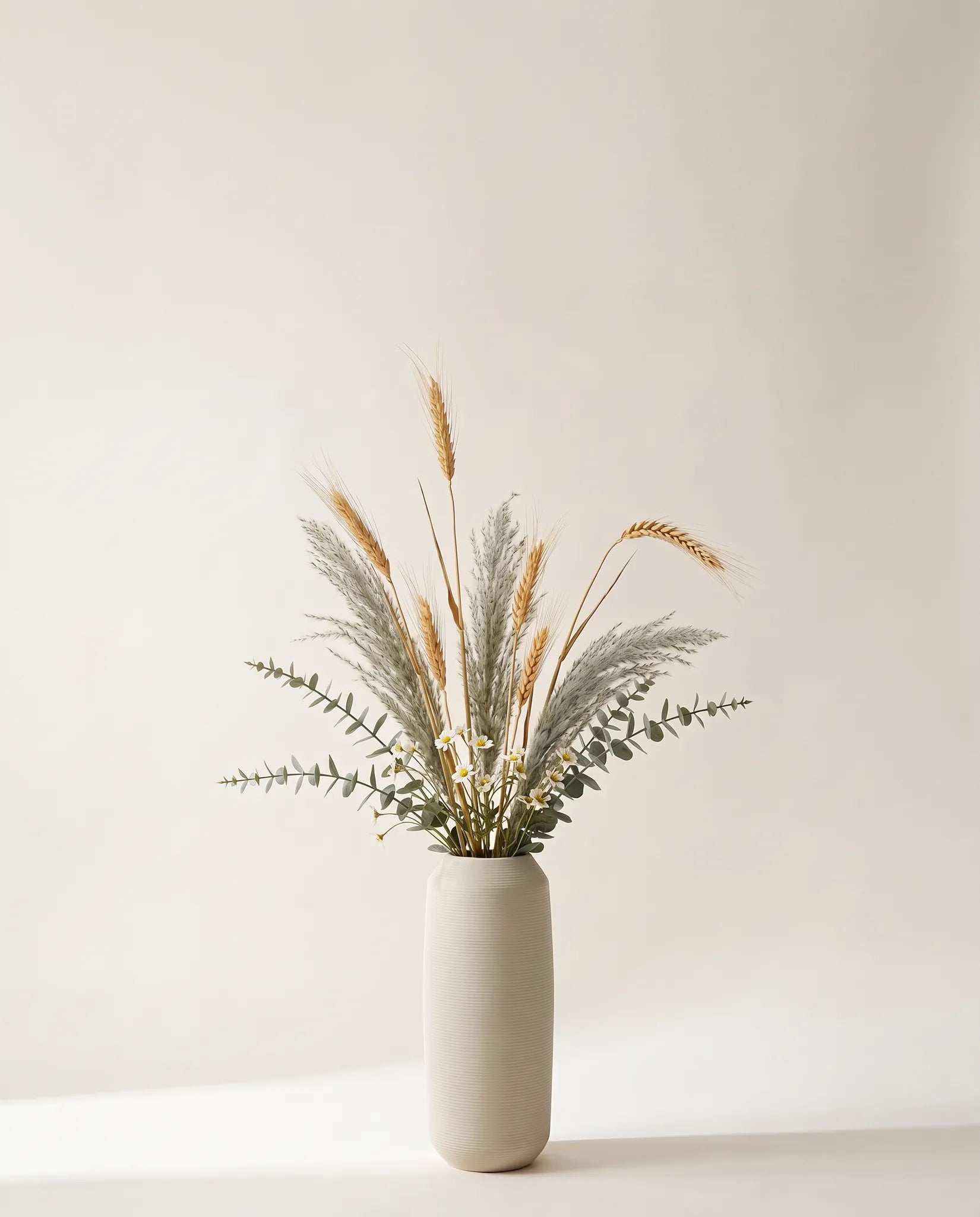 Plante artificielle d'eucalyptus, pennisetum et blé doré et vert-gris dans un vase en céramique
