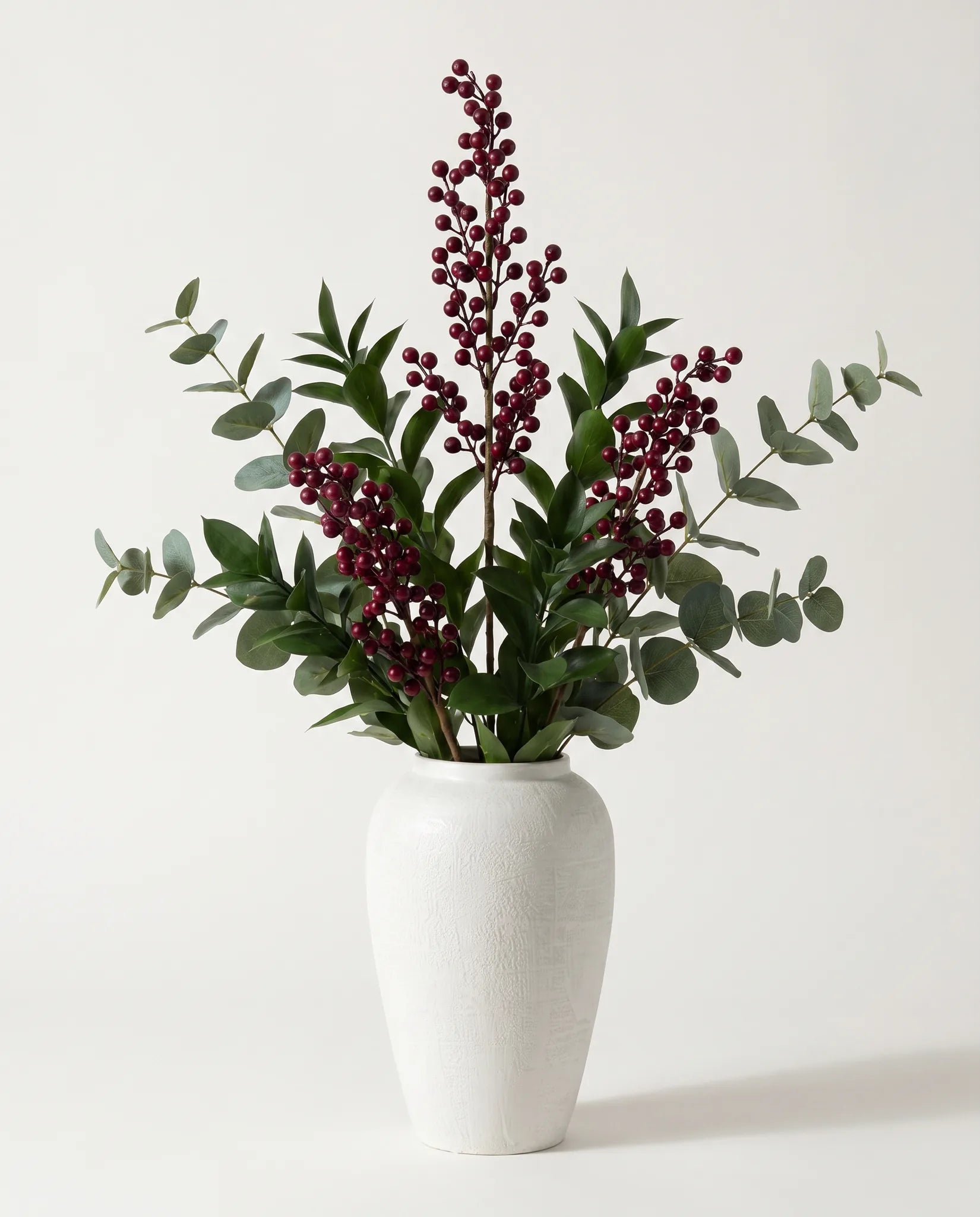 Branches artificielles de baies, ruscus et eucalyptus vert-foncé et bordeaux en gros plan