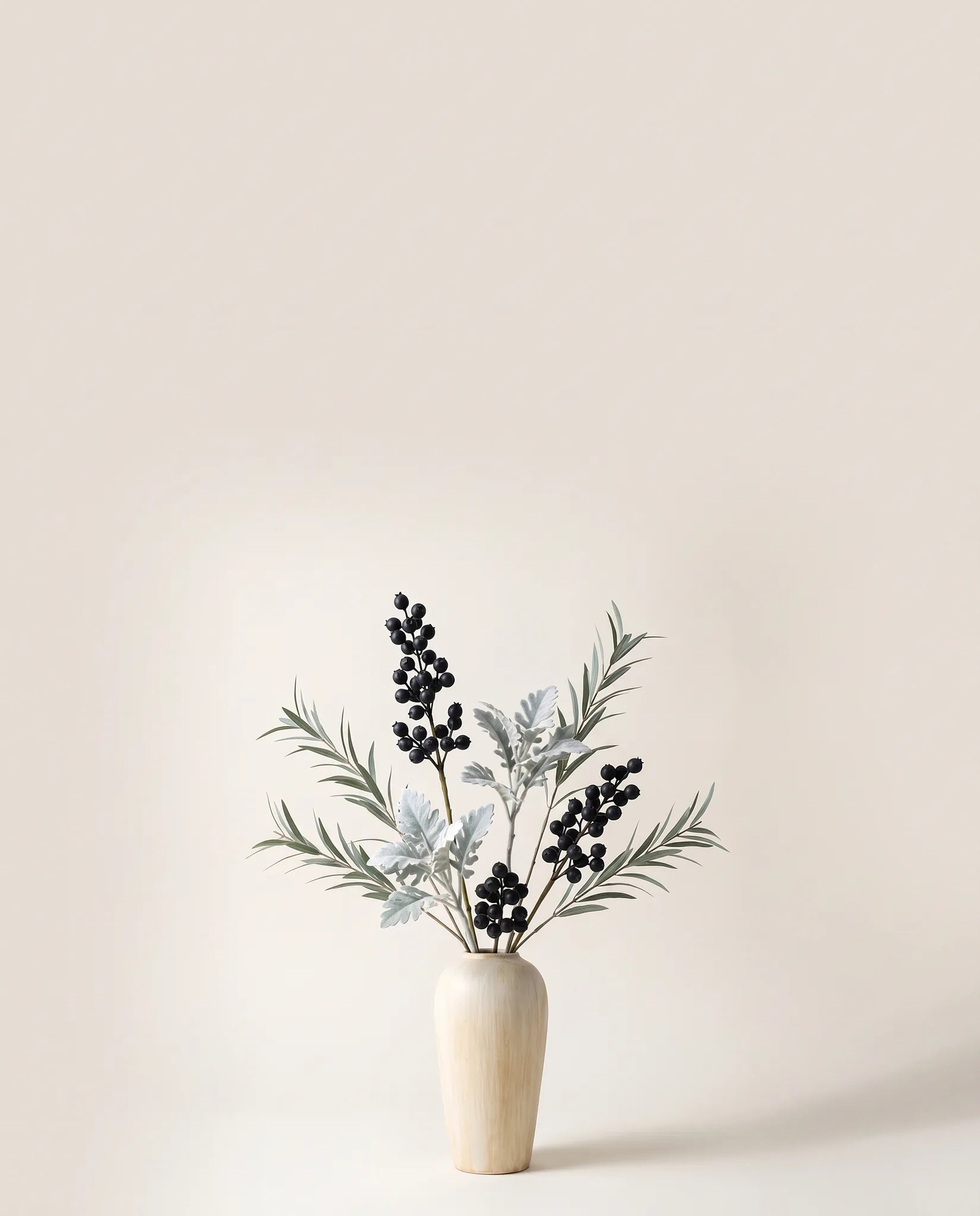 Feuillage artificiel de baies, cinéraire et eucalyptus vert argenté et noir dans un vase en céramique
