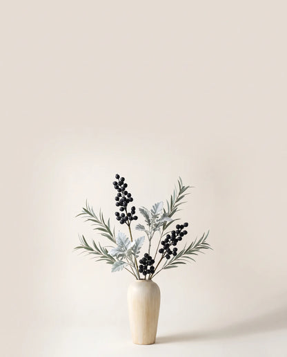 Feuillage artificiel de baies, cinéraire et eucalyptus vert argenté et noir dans un vase en céramique