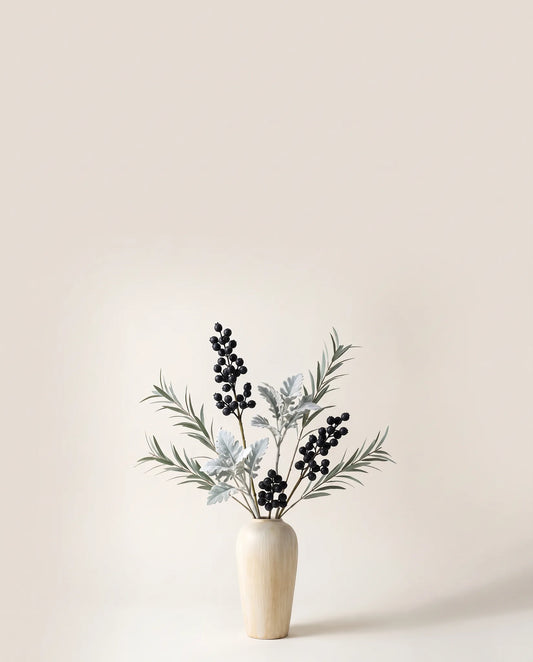 Feuillage artificiel de baies, cinéraire et eucalyptus vert argenté et noir dans un vase en céramique