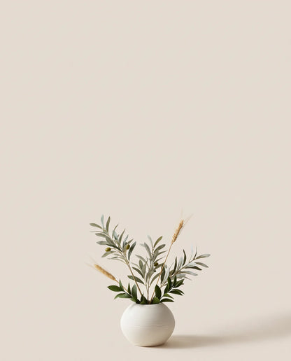 Petite plante artificielle d'olivier, ruscus et blé vert-olive et doré dans un vase en céramique